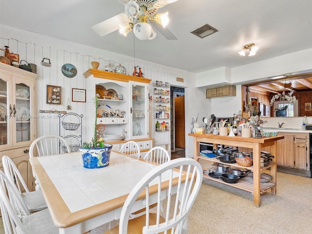 dining area featuring wood walls and ceiling fan