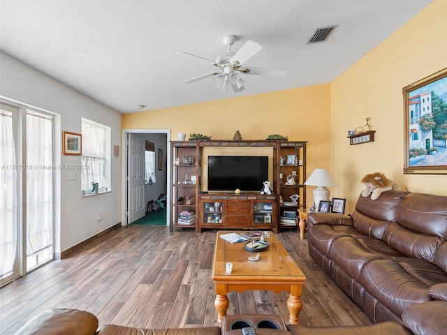 living room with ceiling fan, a textured ceiling, hardwood / wood-style flooring, and lofted ceiling