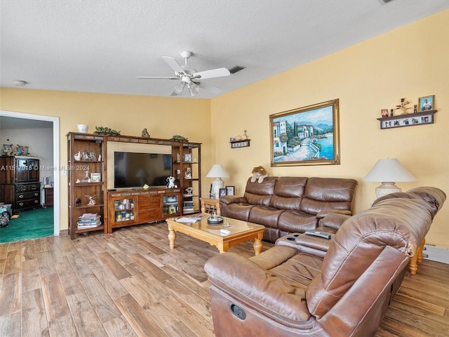 living room featuring a textured ceiling, ceiling fan, wood-type flooring, and vaulted ceiling