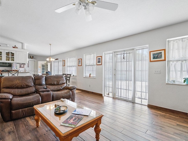 living room with vaulted ceiling, a textured ceiling, ceiling fan, and dark hardwood / wood-style floors