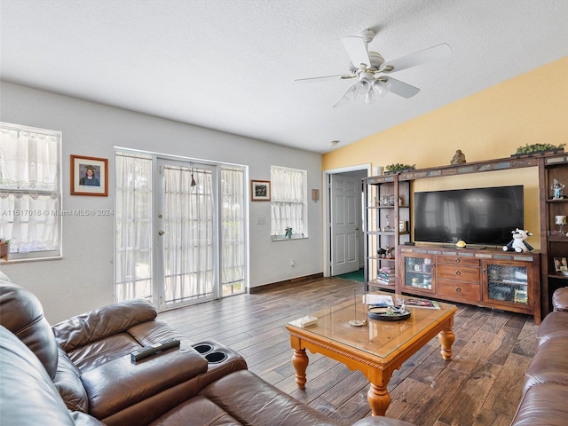 living room featuring a textured ceiling, dark hardwood / wood-style flooring, lofted ceiling, and ceiling fan