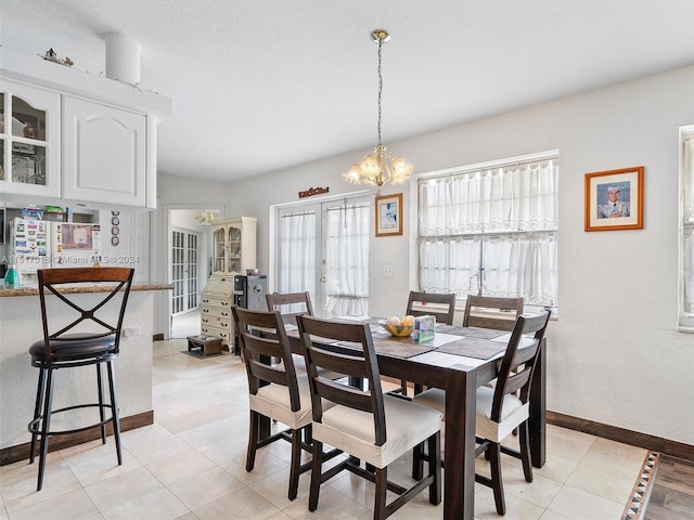 tiled dining space with french doors and a chandelier