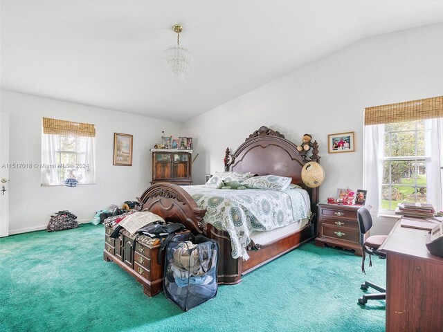 bedroom with carpet floors, lofted ceiling, and a chandelier