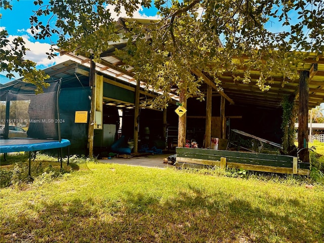 exterior space featuring a trampoline and a front lawn