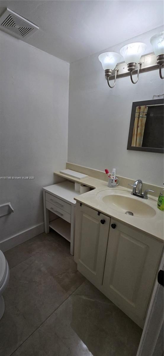 bathroom featuring vanity, tile patterned floors, and toilet