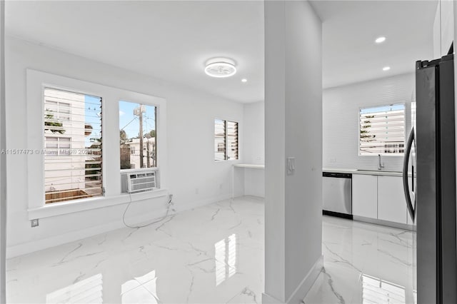 spare room featuring light tile floors, plenty of natural light, and sink