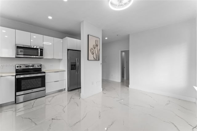 kitchen featuring appliances with stainless steel finishes, white cabinetry, tasteful backsplash, and light tile flooring