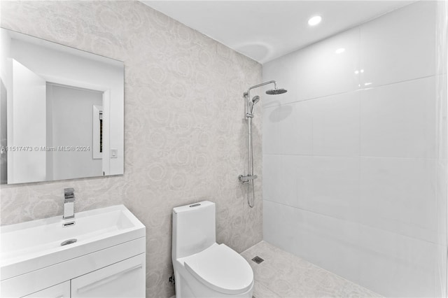 bathroom featuring toilet, vanity, and tiled shower