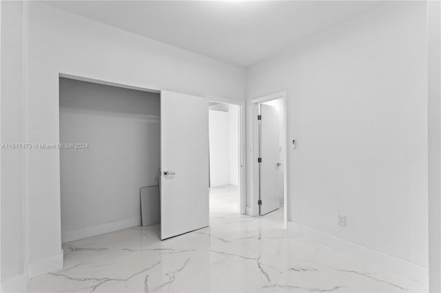 unfurnished bedroom with a closet and light tile floors