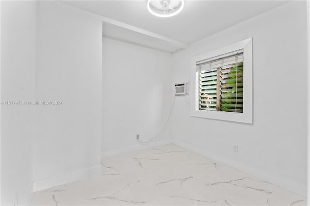 tiled spare room featuring a wall unit AC