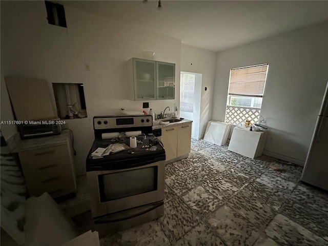 kitchen featuring tile flooring, sink, and stainless steel appliances