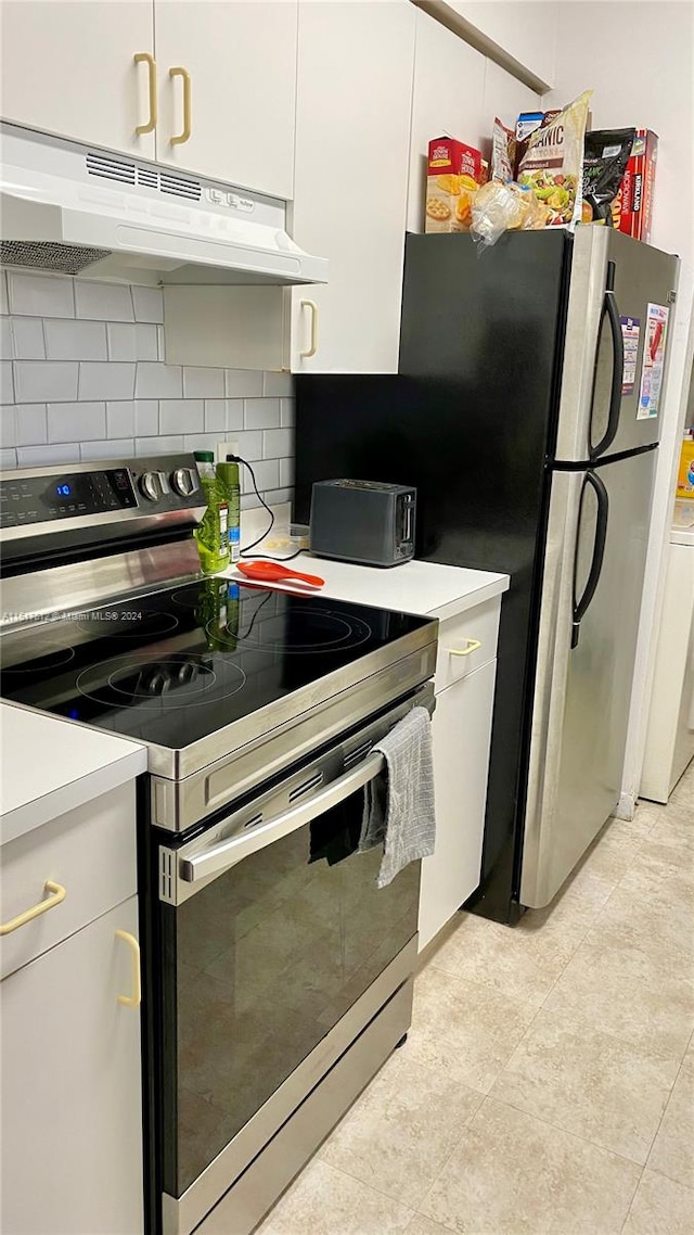 kitchen with light tile floors, white cabinets, stainless steel electric range oven, and backsplash