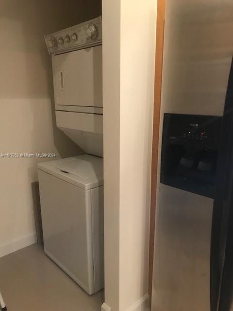 clothes washing area featuring stacked washing maching and dryer