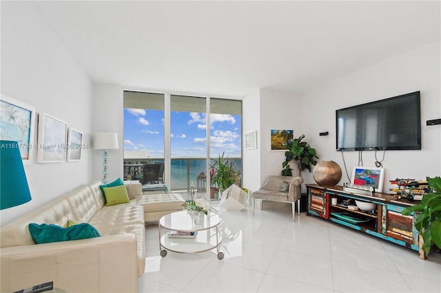 tiled living room featuring floor to ceiling windows and a water view