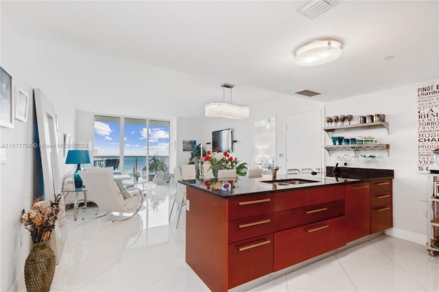 kitchen featuring a water view, pendant lighting, light tile floors, and sink