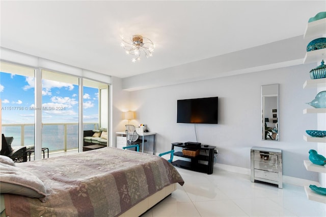 bedroom featuring light tile floors, a notable chandelier, floor to ceiling windows, and a water view