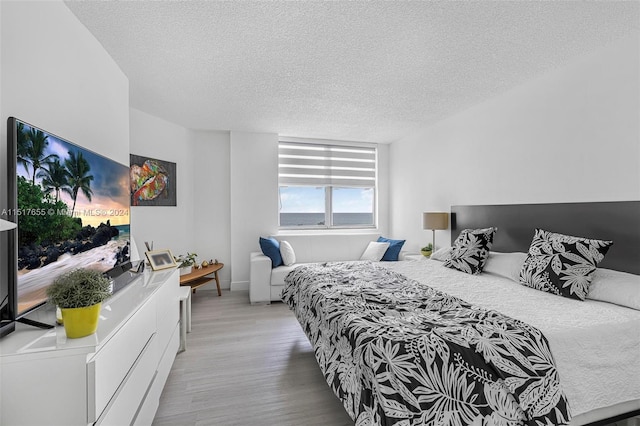 bedroom featuring a textured ceiling and light hardwood / wood-style floors