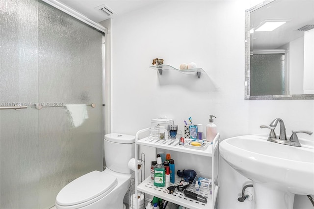 bathroom with toilet, walk in shower, and sink