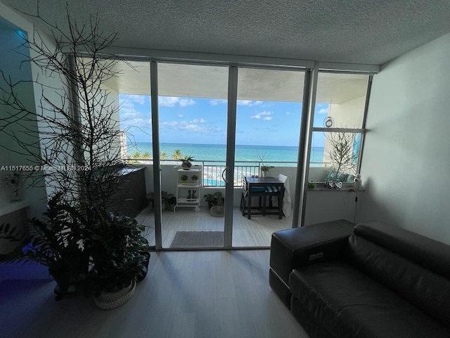 living room featuring a water view, a textured ceiling, and hardwood / wood-style flooring