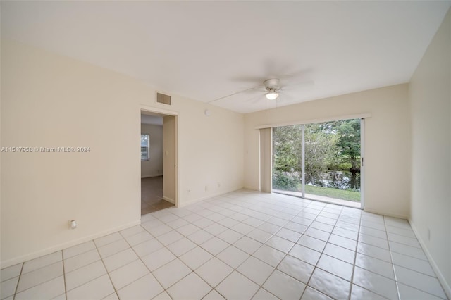 tiled spare room featuring ceiling fan