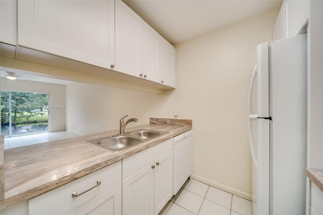 kitchen with white appliances, white cabinetry, sink, and light tile flooring