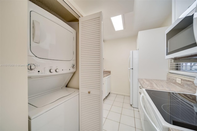 washroom featuring light tile floors and stacked washer and clothes dryer