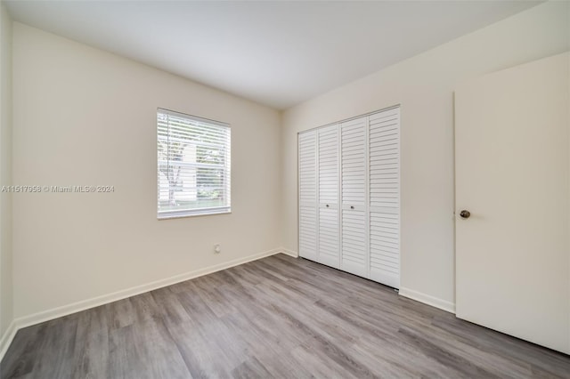 unfurnished bedroom featuring a closet and dark hardwood / wood-style floors