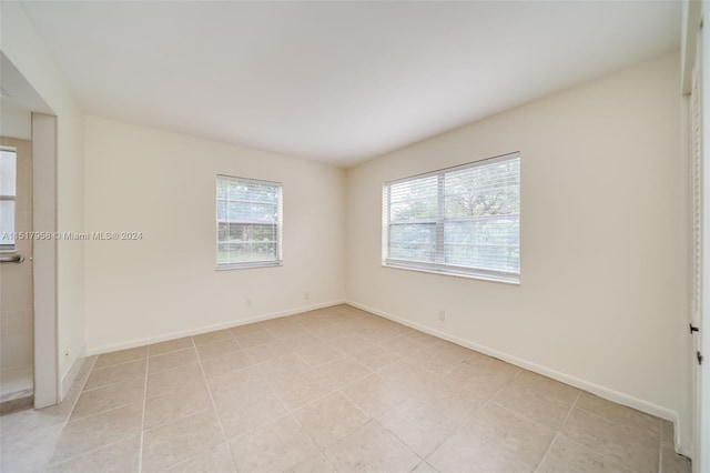 tiled empty room with a wealth of natural light