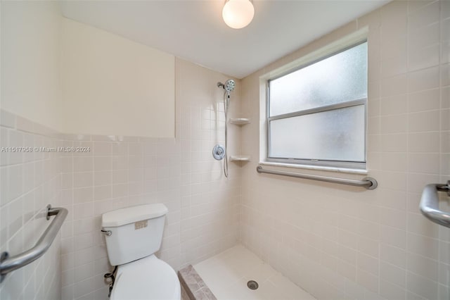 bathroom with toilet, tile walls, and tiled shower