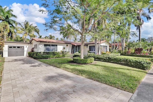 view of front of property with a front yard and a garage