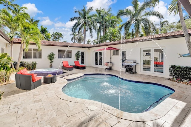 view of pool with a patio area, pool water feature, and french doors