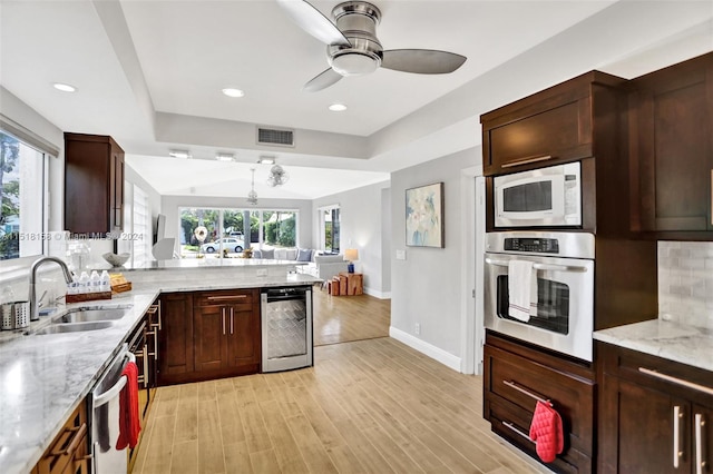 kitchen with plenty of natural light, light wood-type flooring, appliances with stainless steel finishes, and beverage cooler