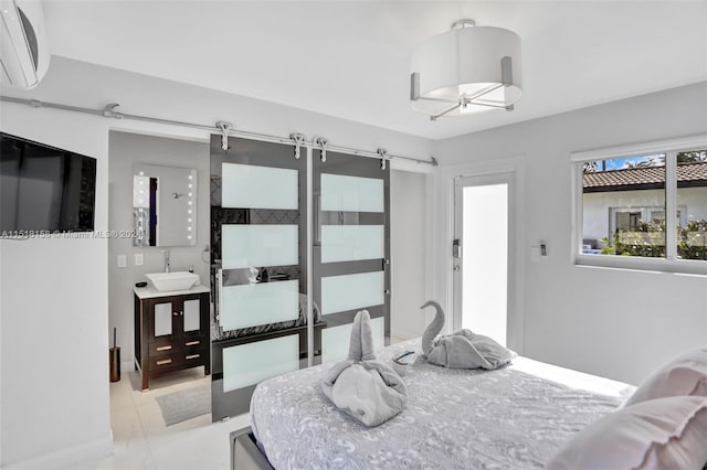 bedroom with a barn door, light tile flooring, sink, and an AC wall unit