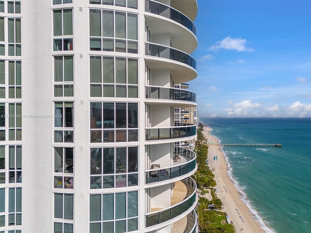 view of building exterior with a water view and a view of the beach