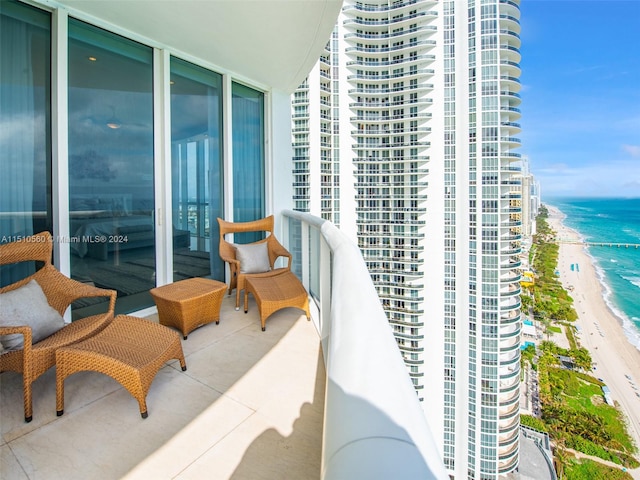 balcony featuring a beach view and a water view