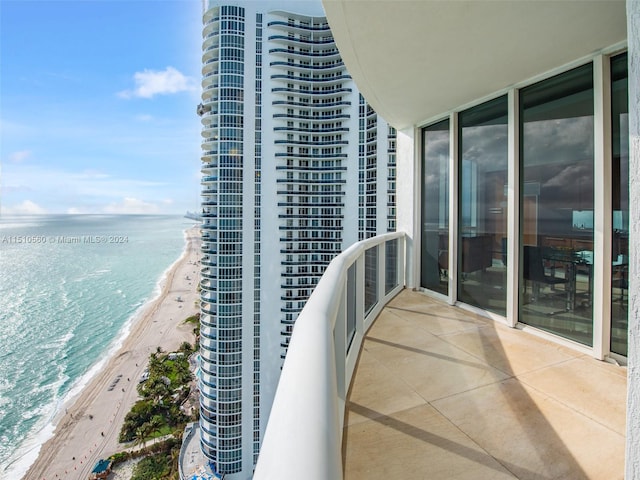 balcony featuring a beach view and a water view