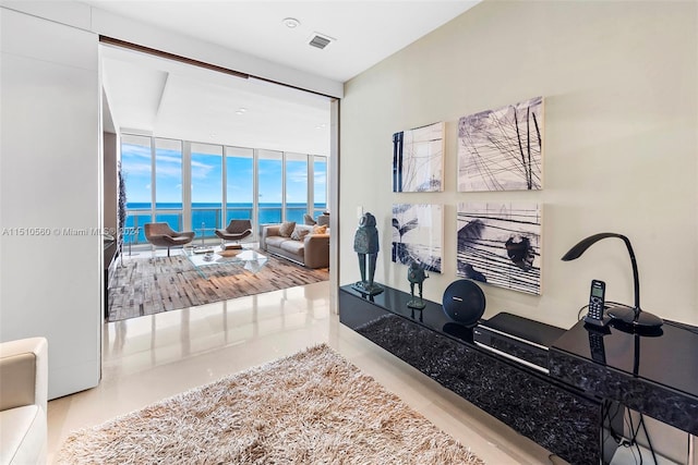 interior space featuring floor to ceiling windows, wood-type flooring, and a water view