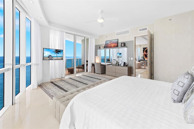 tiled bedroom featuring a water view, access to outside, ceiling fan, and a wall of windows