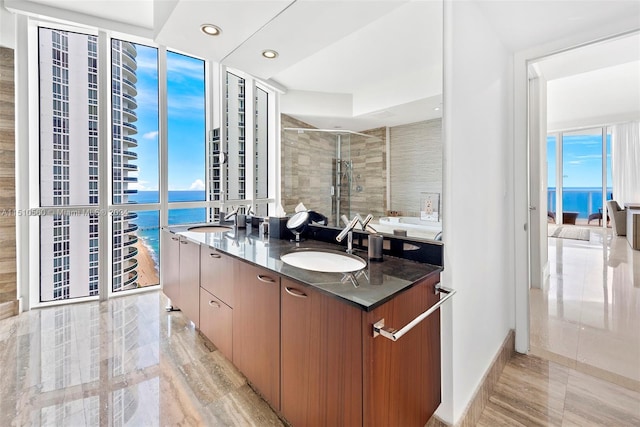 bathroom featuring dual vanity, a wall of windows, a water view, tile flooring, and an enclosed shower