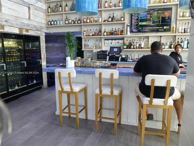 bar featuring beverage cooler and dark hardwood / wood-style flooring