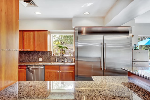 kitchen featuring backsplash, plenty of natural light, sink, and stainless steel appliances