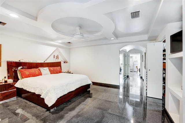 bedroom featuring ceiling fan and a raised ceiling