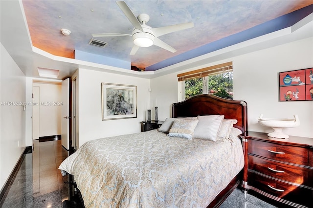 bedroom featuring a raised ceiling and ceiling fan