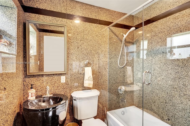 full bathroom with backsplash, sink, shower / bath combination with glass door, tile walls, and toilet