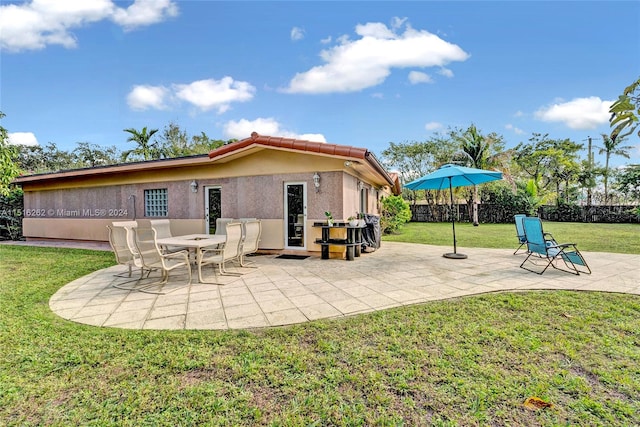 rear view of house featuring a yard and a patio