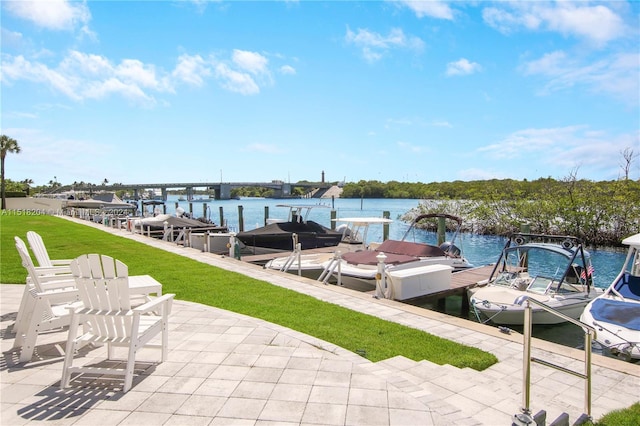 dock area with a lawn and a water view