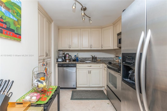 kitchen with cream cabinetry, sink, and stainless steel appliances