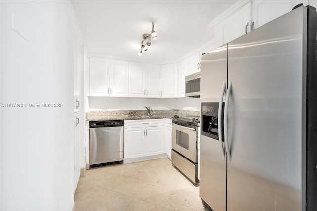 kitchen with white cabinets, sink, ornamental molding, light stone counters, and stainless steel appliances