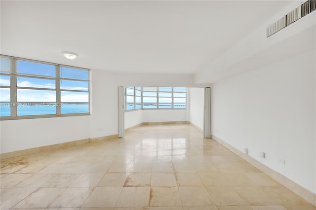 tiled spare room with a water view