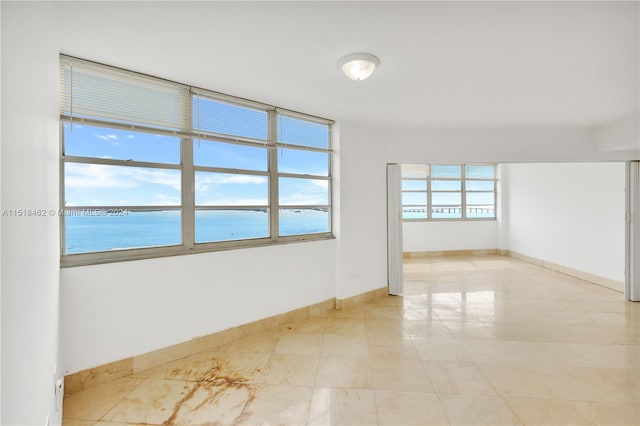 unfurnished room featuring a water view